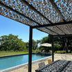 Rete mimetica rinforzata grigia sopra una pergola accanto alla piscina
