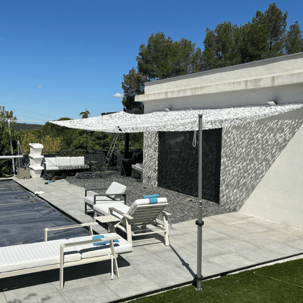 Palo telescopico in alluminio con rete mimetica bianca accanto a una piscina
