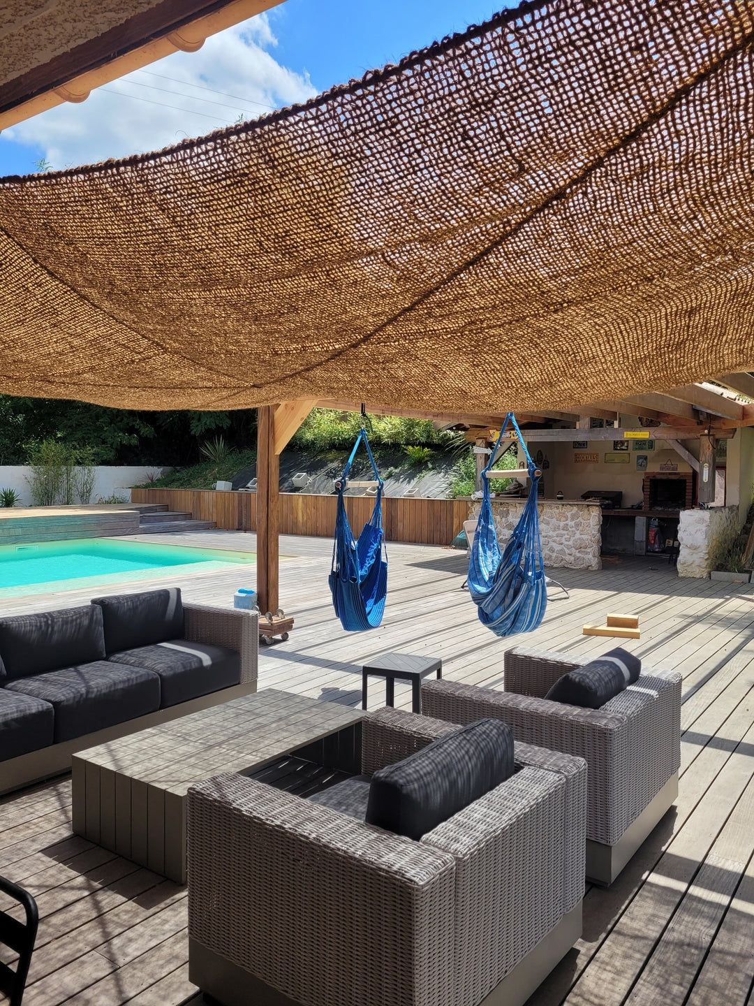 Telo ombreggiante in cocco sopra una zona relax accanto alla piscina