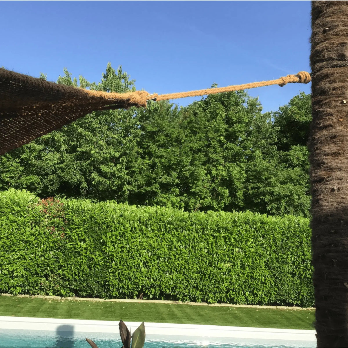 Corda in fibra di cocco che fissa un telo ombreggiante in cocco accanto a una piscina