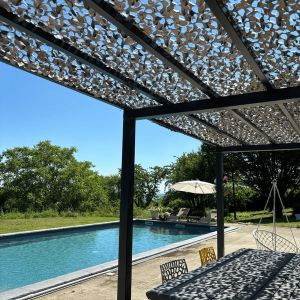 Rete mimetica rinforzata grigia sopra una pergola accanto alla piscina